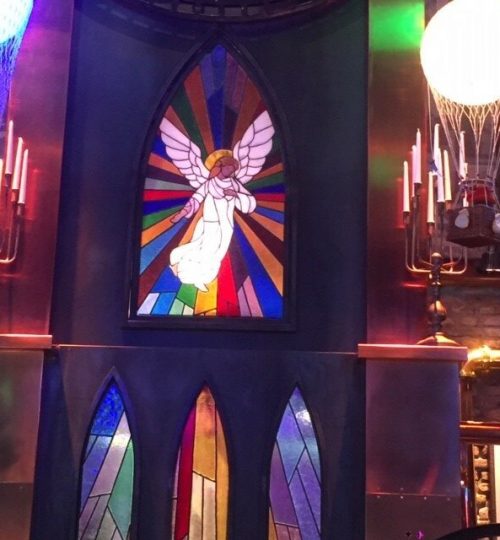 De engel word door een lamp van achteren verlicht en straalt met zijn licht over de bar.